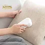 دستگاهی کوچک و سفید در حال تمیز کردن یک بالش روشن.
