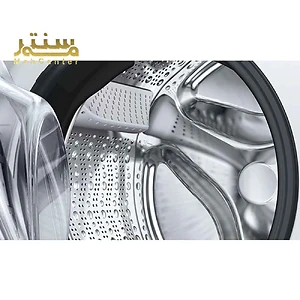 نمای نزدیک از درام استیل ضد زنگ ماشین لباسشویی با طراحی مدرن.