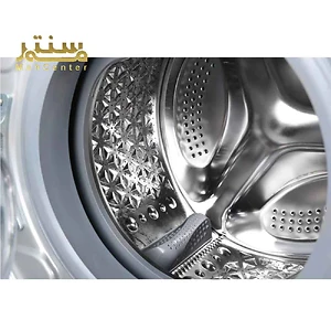در تصویر داخلی یک ماشین لباسشویی با دیگ استیل و طراحی موج‌دار دیده می‌شود