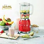 تصویر یک مخلوط‌کن قرمز SMEG است که با میوه‌های تازه مانند توت‌فرنگی، موز، کیوی و سیب پر شده است و در کنار آن مواد دیگری مانند شیر، کاسه غلات، و لیوان اسموتی آماده دیده می‌شود.