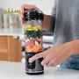 مخلوط‌کن قابل حمل نینجا در حال آماده‌سازی ترکیبی از میوه‌ها و سبزیجات.