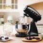 یک همزن برقی مشکی رنگ SMEG با طراحی کلاسیک و کاسه استیل در حال هم زدن مواد غذایی.
