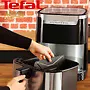 Alt: "تصویری از یک سرخ‌کن تفال Easy Fry & Grill XXL در حال استفاده، با دستی که قسمت داخلی دستگاه را جابجا می‌کند. دستگاه بر روی پیشخوان آشپزخانه قرار دارد."