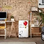 یخچال SMEG با طراحی کارتونی اسنوپی و بالن قرمز در یک اتاق با دیوار آجری و دکوراسیون مدرن.