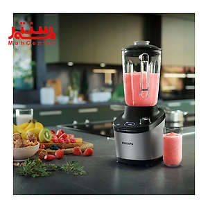 مخلوط کن فیلیپس 3760 که داخل آن میوه میکس شده است و در کنار آن یک لیوان شیشه ای قرار دارد که داخل آن هم آبمیوه است. روی کابیت هم مقداری میوه است