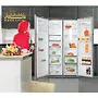 داخل یخچال دارای طبقات شیشه ای، کشوهای پلاستیکی و محفظه های درب است. یک زن با روسری قرمز در حال برداشتن یک بطری آب از یخچال است