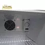 یک نمای نزدیک از داخل یک یخچال با یک قفسه شیشه ای و یک کنترل کننده دما.