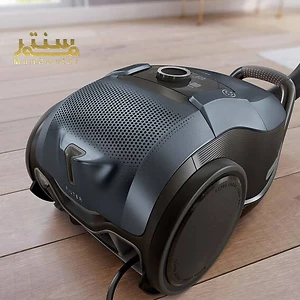 یک جاروبرقی مشکی روی یک کف چوبی.