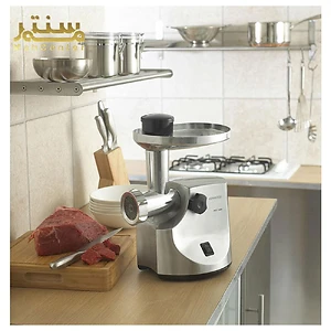 این تصویر یک چرخ گوشت Kenwood MG510 را در یک پس‌زمینه با وسایل آشپزخانه نشان می‌دهد.