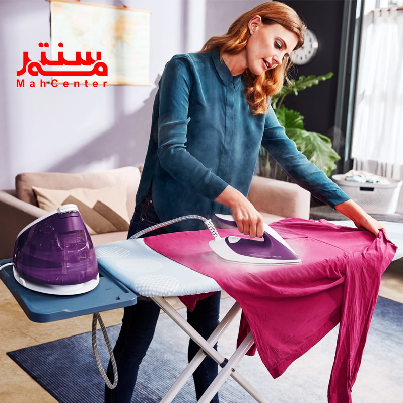 خانمی با لباس سرمه ای که در حال اتوی کشی یک پیراهن سرخابی با اتوی فیلیپس 7930 است