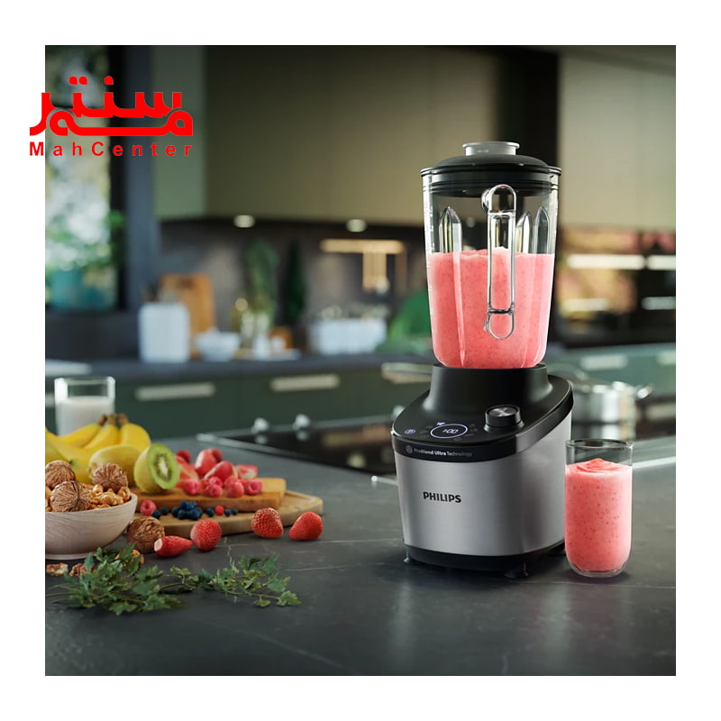 مخلوط کن فیلیپس 3760 که داخل آن میوه میکس شده است و در کنار آن یک لیوان شیشه ای قرار دارد که داخل آن هم آبمیوه است. روی کابیت هم مقداری میوه است