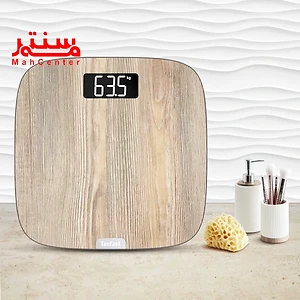 ترازو تفال مدل pp1600 که روی کابیت حمام است و کنار آن جای مایع و استند براش قرار دارد.