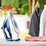 اتو بخار تفال مدل fv5751 روی یک سطح که کنار آن یک لباس صورتی قرار دارد و پشت آن دو تا لباس آویزان است.