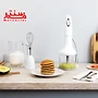 خردکن اسمگ مدل hbf03 سفید که در آن سس پسته است، در کنار آن هم دسته همزن دستی و جلوی آن بشقاب سفیدی که در آن 6تا پنکیک است.