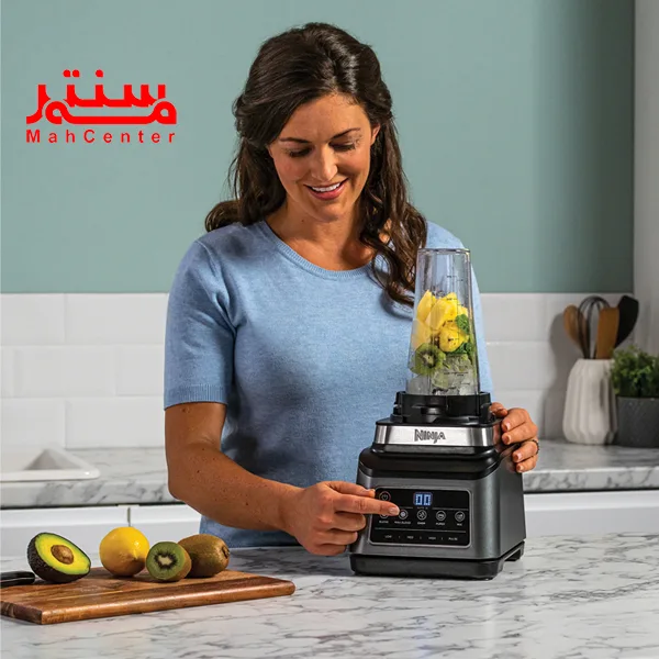 خانمی در حال میکس کیوی و آناناس با شیکر نینجا مدل bn800 است و در کنار آن کیوه، آووکادو و لیموترش است.