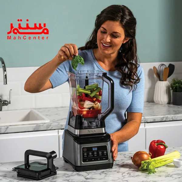 خانمی با لباس آبی رنگ که در حال ریختن اسفناج داخل پارخ مخلوط کن غذاساز مدل bn800 است