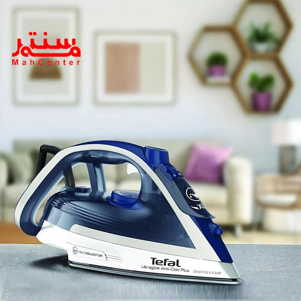 اتو تفال مدل fv5820 که روی یک سطح صاف قرار دارد و پشت آن دکور خانه مشخص است.