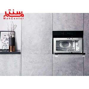 فر مایکروویو آریستون 996 که داخل کابیت طوسی رنگ کار شده و درب آن رو به پایین باز شده و فن داخل آن مشخص است.