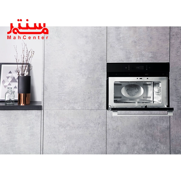 فر مایکروویو آریستون 996 که داخل کابیت طوسی رنگ کار شده و درب آن رو به پایین باز شده و فن داخل آن مشخص است.