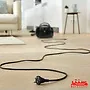 این تصویر یک جاروبرقی مشکی رنگ را در یک اتاق نشان می‌دهد که توسط برند «MahCenter» ارائه شده است.
