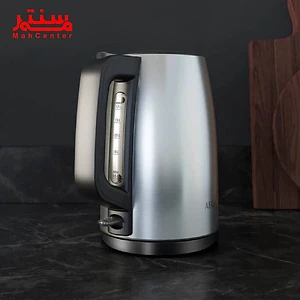 یک کتری برقی AEG K3-1-3ST در پس زمینه یک آشپزخانه نشان داده شده است. کتری از جنس استیل ضد زنگ است و دارای یک پایه مشکی است.