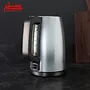 یک کتری برقی AEG K3-1-3ST در پس زمینه یک آشپزخانه نشان داده شده است. کتری از جنس استیل ضد زنگ است و دارای یک پایه مشکی است.