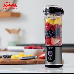 یک مخلوط‌کن قابل‌حمل نینجا حاوی میوه‌های تازه مانند توت‌فرنگی، بلوبری، و آناناس روی پیشخوان آشپزخانه.